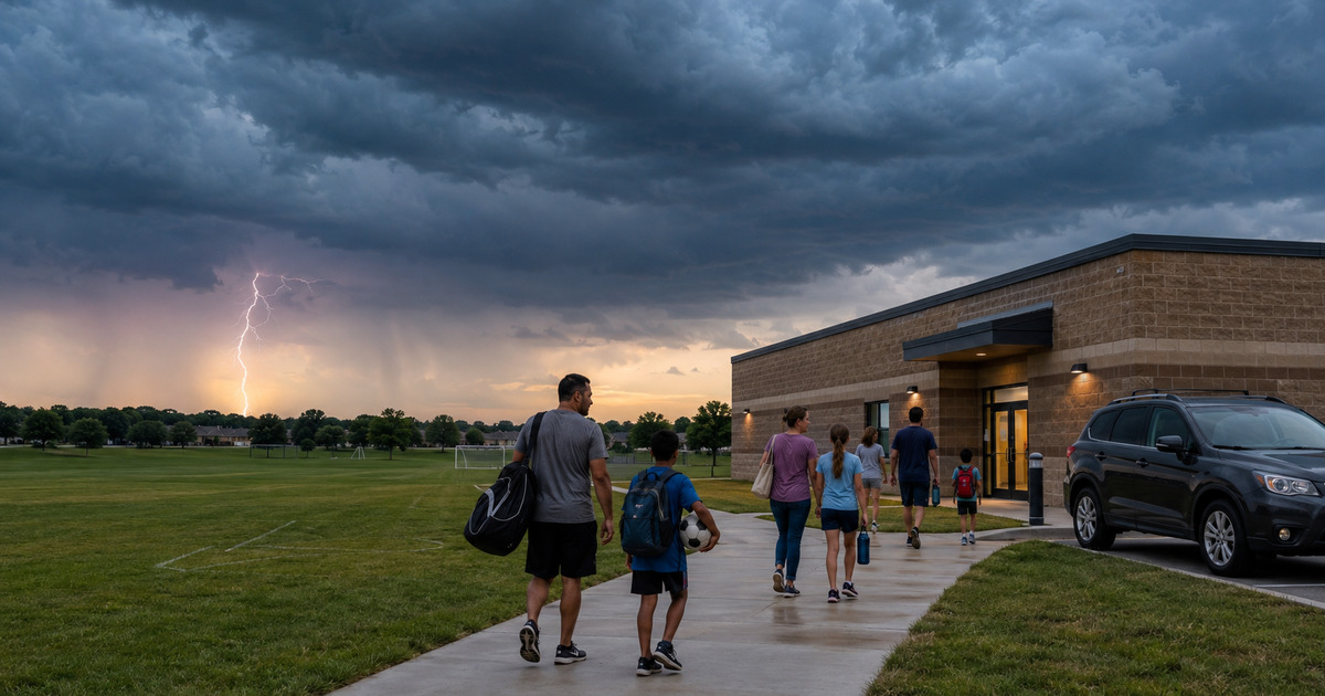 People moving from an outdoor field toward a substantial building and enclosed vehicle as lightning approaches